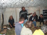 joto from colombia performing a rap song in the bar tent
he had earlier led a workshop on the situation for afro-colombians in the south-west of the country.
on the left of joto is andreas from germany and on the right salih from baghdad right - it was truly an international camp
as joto's main language was spanish, yolanda from madrid often translated for him