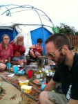 Photo by Mil
then on the tuesday it was time for those of us left to begin tat down (dismantling the plumbing, clearing and tidying the site.
as veggies had gone we were back to beth's supplies - here eating outside patrick's dome, the only structure left apart from our own tents.
that evening we watched some photos of summer camp taken by yolanda's children projected on a screen in patrick's tent whilst outside...