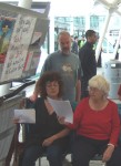 singers with the main entrance to the arms fair in the background