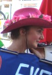 a colourfully hatted demonstrator bearing...