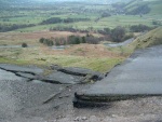 here the left part of the road has dropped several feet leaving a ledge - down in the valley below can be seen the lower section of the road heading for Castleton