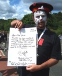 This time Arms Around the Base at Faslane Nuclear base on the Clyde 
Here a member of the Clandestine Insurgent Rebel Clown Army holds up their petition
