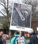 this participant was selling postcards, the copy on the placard symbolising corporate greed.