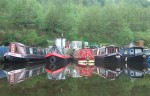 canal boats perfectly mirrored in the still waters
